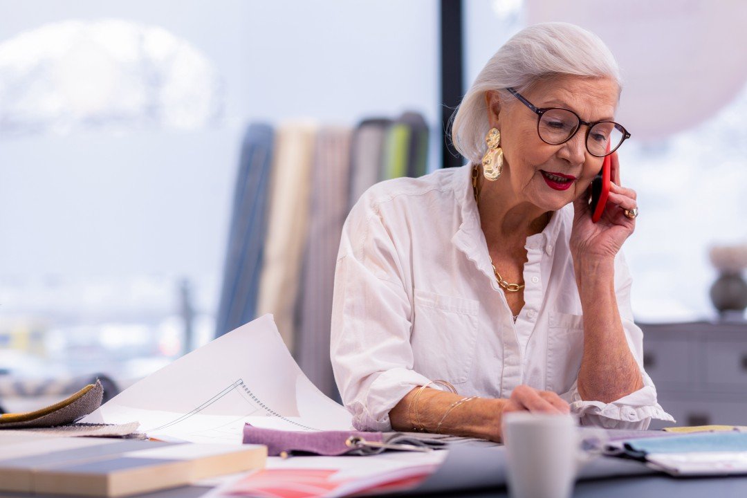 oudere dame aan telefoon op werk secretaresse aan het werk voor Veluwe65plus uitzendbureau